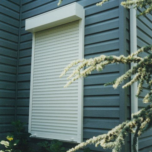 white roll-up closed over a side window of gray panelled home.